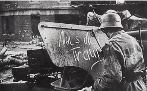 A German soldier of the Panzer Lehr Division scrawls "Aus der Traum" ("the dream is over") on an ...