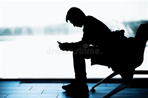 Silhouette of a Young Man with a Smartphone in a Waiting Room Stock ...