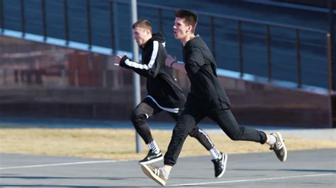 Two young men performing acrobatic parkour tricks. Overcoming obstacles Stock Video Footage ...