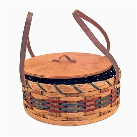 a wooden basket with leather handles and straps