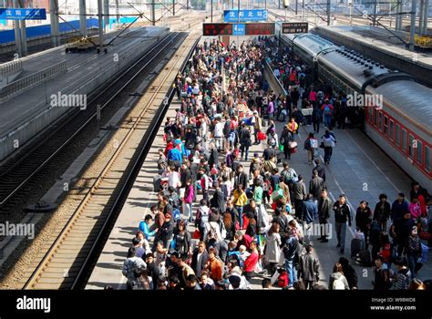 Crowds of Chinese passengers wait for a train on the platform at the Shenyang North Railway ...