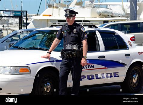 Policeman standing by his police car Stock Photo - Alamy