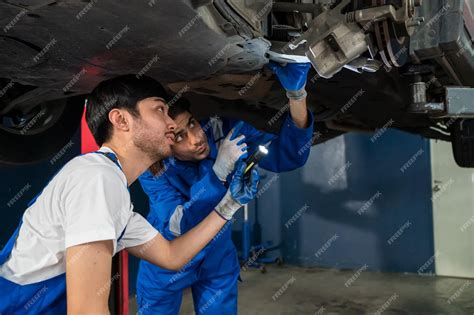 Premium Photo | Mechanic in blue overalls checking serviceability of ...