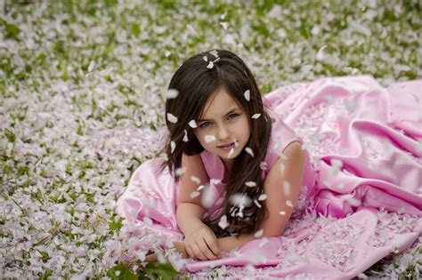 Premium Photo | Little girl on green grass with petals