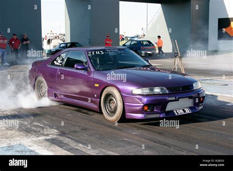 Modified Japanese R33 Nissan Skyline car performing a tyre warming burnout prior to a quarter ...