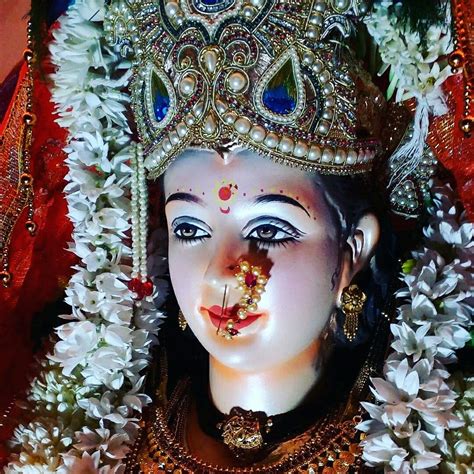 a statue of a woman with flowers around her neck and nose, wearing a tiara