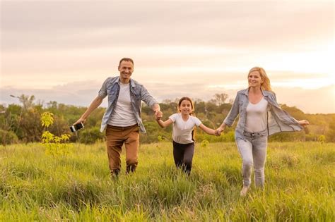 Joven familia feliz en un campo. | Foto Premium