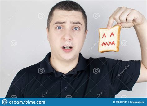 Conceptually about Gluten Intolerance. the Man Holds in His Hand a Piece of Bread on Which an ...
