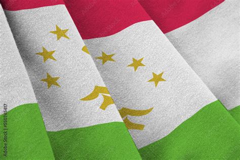 Tajikistan flag with big folds waving close up under the studio light indoors. The official ...