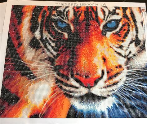 a cross stitch picture of a tiger with blue eyes