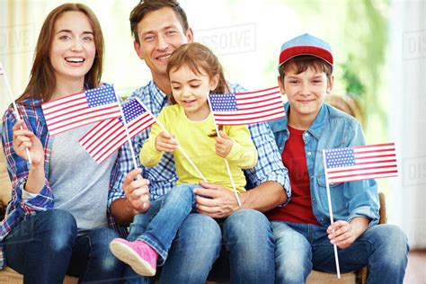 Happy family with flags of USA celebrating Independence Day - Stock Photo - Dissolve