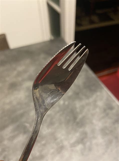 This spork is made out of stainless steel and has a jagged knife edge ...