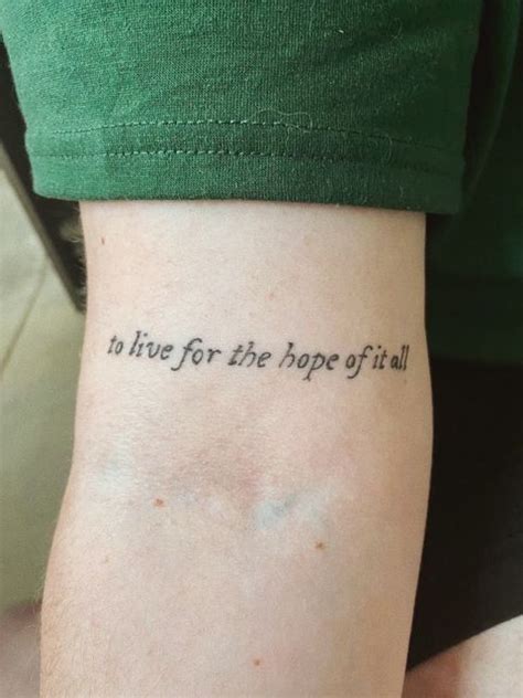 a person with a tattoo on their arm that says to live for the hope of it all