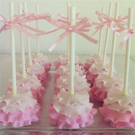 cupcakes with pink and white frosting on a clear plate, tied with ribbons