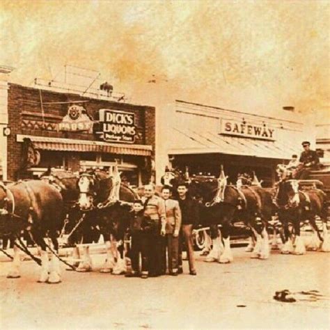 an old photo of horses and people in front of a store