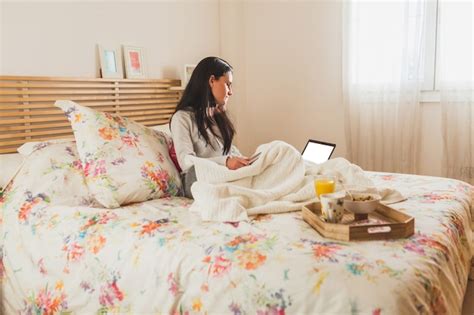 Free Photo | Brunette girl working with her laptop in the bed