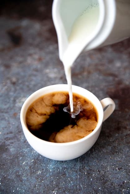 Free Photo | Pouring milk in coffee cup