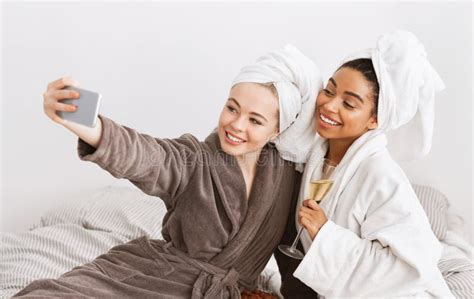 Two Multiraced Women Taking Selfie in Bathrobes, Having Spa Day Stock ...