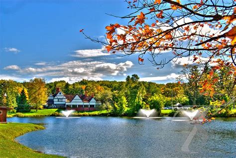 a lake surrounded by lots of trees with water spouting from it's sides