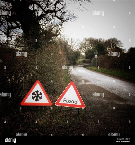 Ice on road with flood traffic warning signs in Cheshire Uk Stock Photo - Alamy