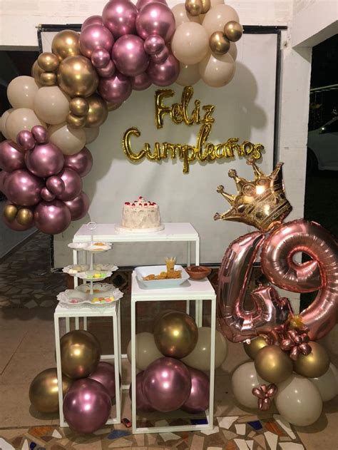 a table topped with balloons and a cake