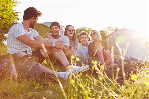 Group Of Friends Relaxing Outside Tents On Camping Holiday