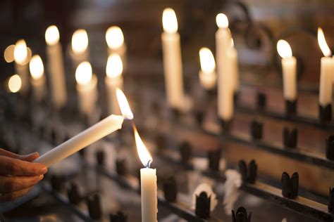 Woman lighting prayer candle - Catholic Recruiter