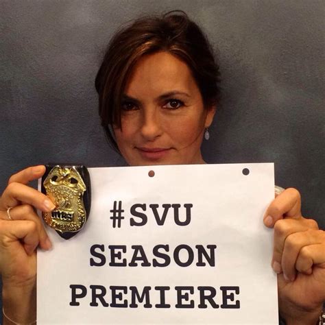 a woman holding up a sign that says svu season premiree on it