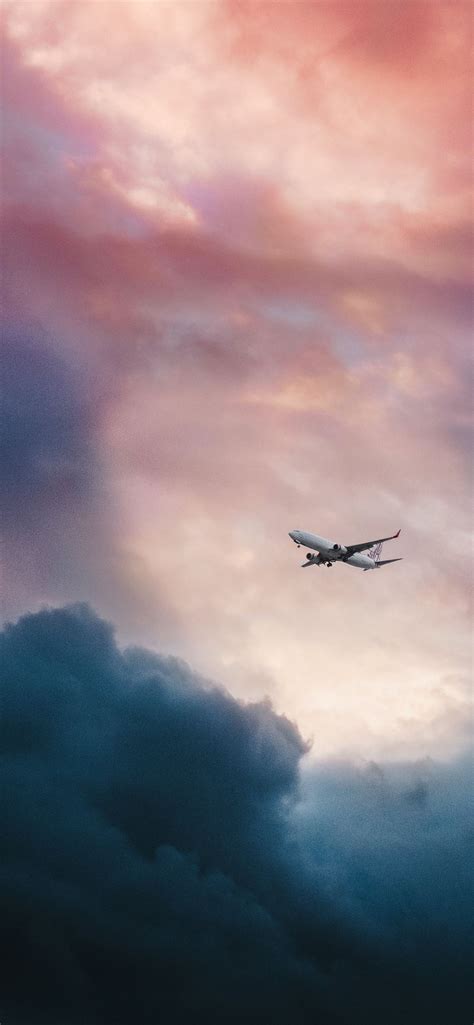 white plane flying over gray clouds iPhone 12 Wallpapers Free Download