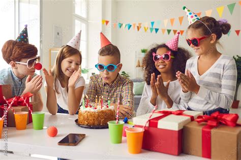 Group of kids celebrating their friend's birthday and clapping hands as ...