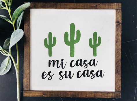 a wooden frame with a green cactus and the words mi casa es su casa