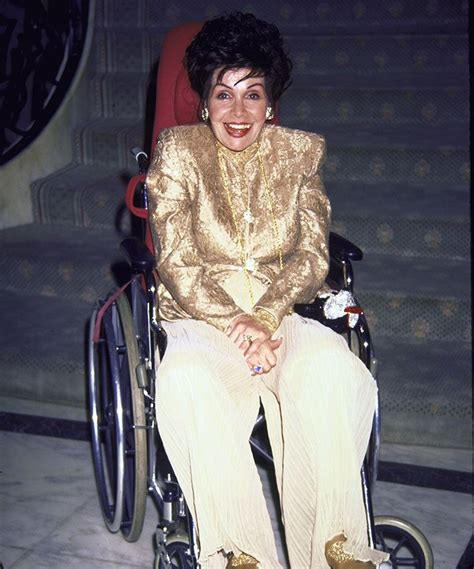 a woman sitting in a wheel chair smiling