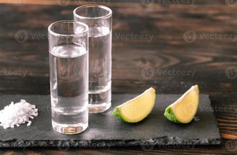 Glasses of tequila with lime wedges 14938394 Stock Photo at Vecteezy