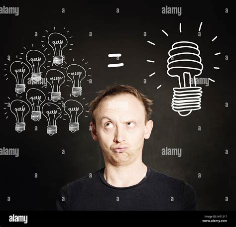 Energy Saving Concept. Man with Traditional and Energy Efficient Light Bulbs on Blackboard ...