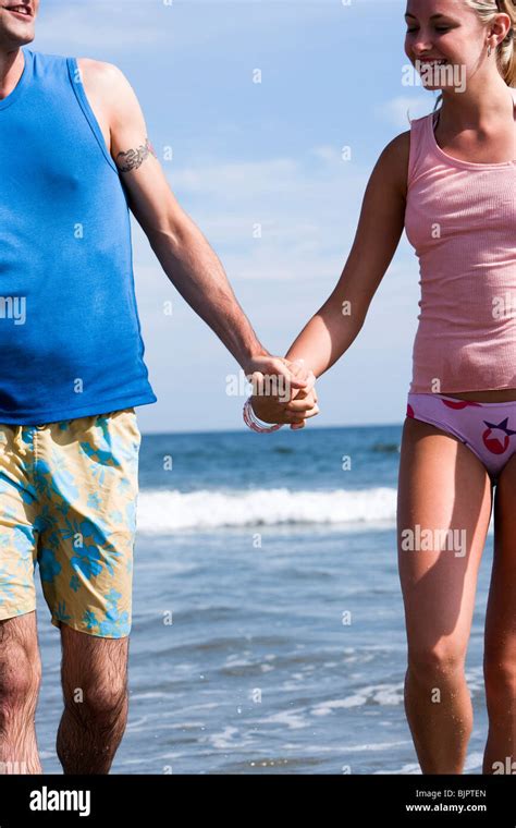 Couple holding hands at the beach Stock Photo - Alamy