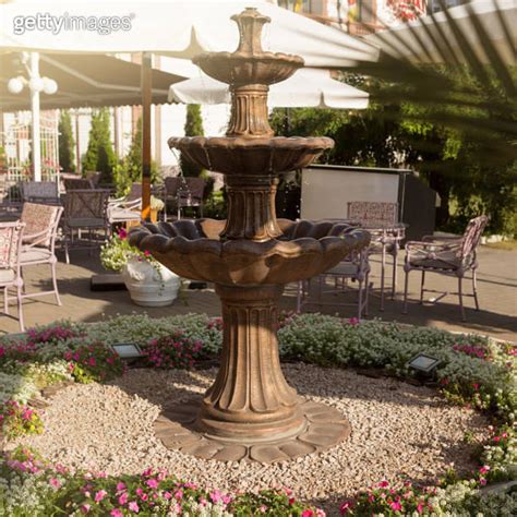 beautiful fountain near the street restaurant, tables and flowers, sunshine, the concept of ...