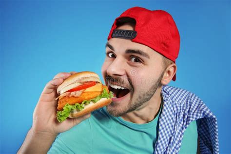 Handsome Man Eating Tasty Burger Stock Photo - Image of closeup, handsome: 142458912