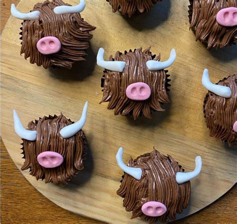 six cupcakes with chocolate frosting and white horns