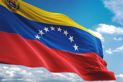 Venezuela With Coat Of Arms Flag Waving Cloudy Sky Background Stock Photo - Download Image Now ...