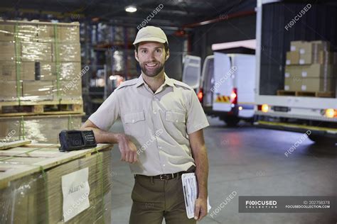 Portrait confident truck driver worker at distribution warehouse loading dock — caucasian ...