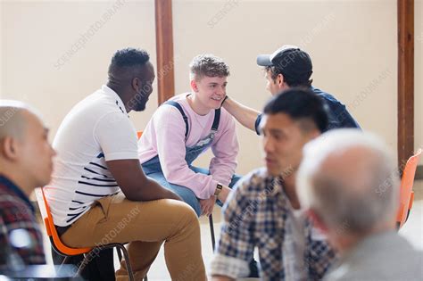 Men talking, comforting in group therapy - Stock Image - F023/9219 - Science Photo Library