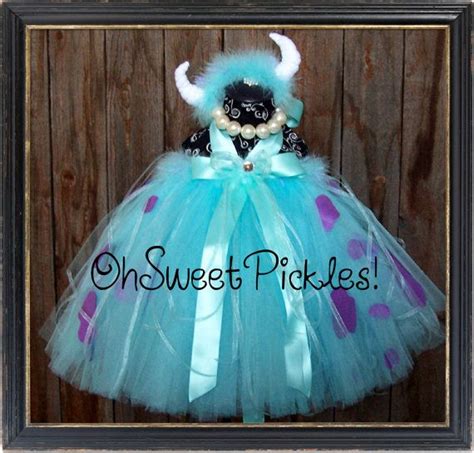 a stuffed animal dressed up in a blue dress with horns and polka dots on it