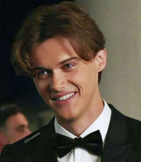 a man in a tuxedo smiles at the camera