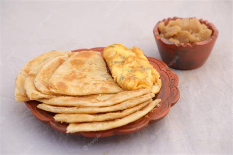 Premium Photo | Desi breakfast omelet halwa and paratha served in dish isolated on background ...