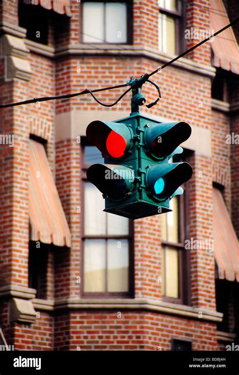 Old fashioned traffic light hanging from cable and red brick building Stock Photo, Royalty Free ...