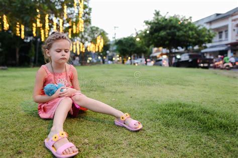 Little Girl Sitting on Grass Lawn, Building on Background. Stock Photo - Image of enjoy ...