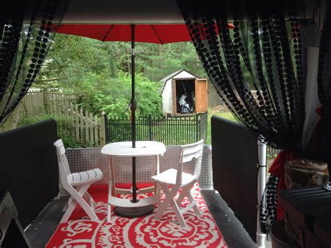 an outdoor table and chairs are set up on the patio with an umbrella ...