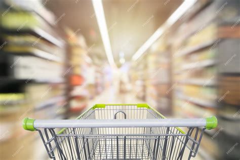 Premium Photo | Shopping cart in supermarket aisle with product shelves interior defocused blur ...