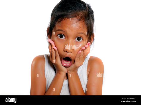 sweet and cute 7 or 8 years old female child shocked and surprised opening mouth in disbelief ...