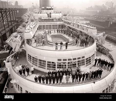 1950s CIRCA 1954 THE ENTIRE CREW OF THE CRUISE SHIP SS CONSTITUTION ASSEMBLED ON THE AFT DECK OF ...